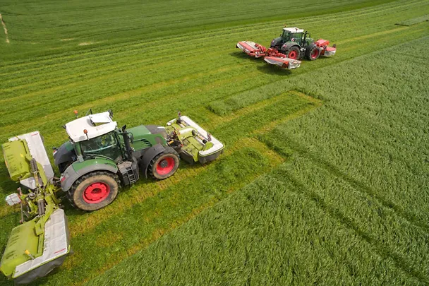 Zwei Traktoren beim Gras mähen