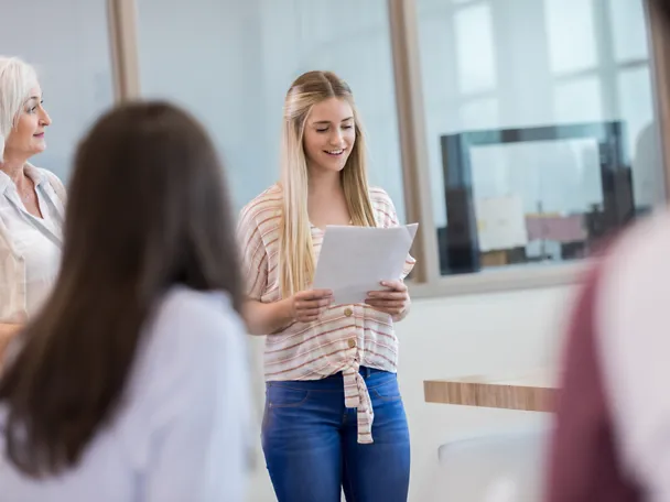 Eine Praktikantin hält vor Menschen einen Vortrag